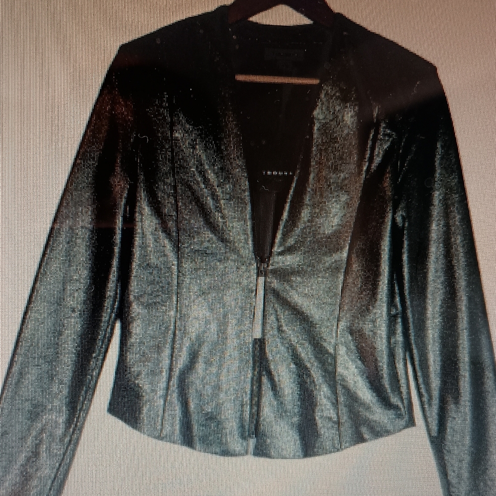 Fitted blazer. Waist length. Shoulder pads. Silver zip front.